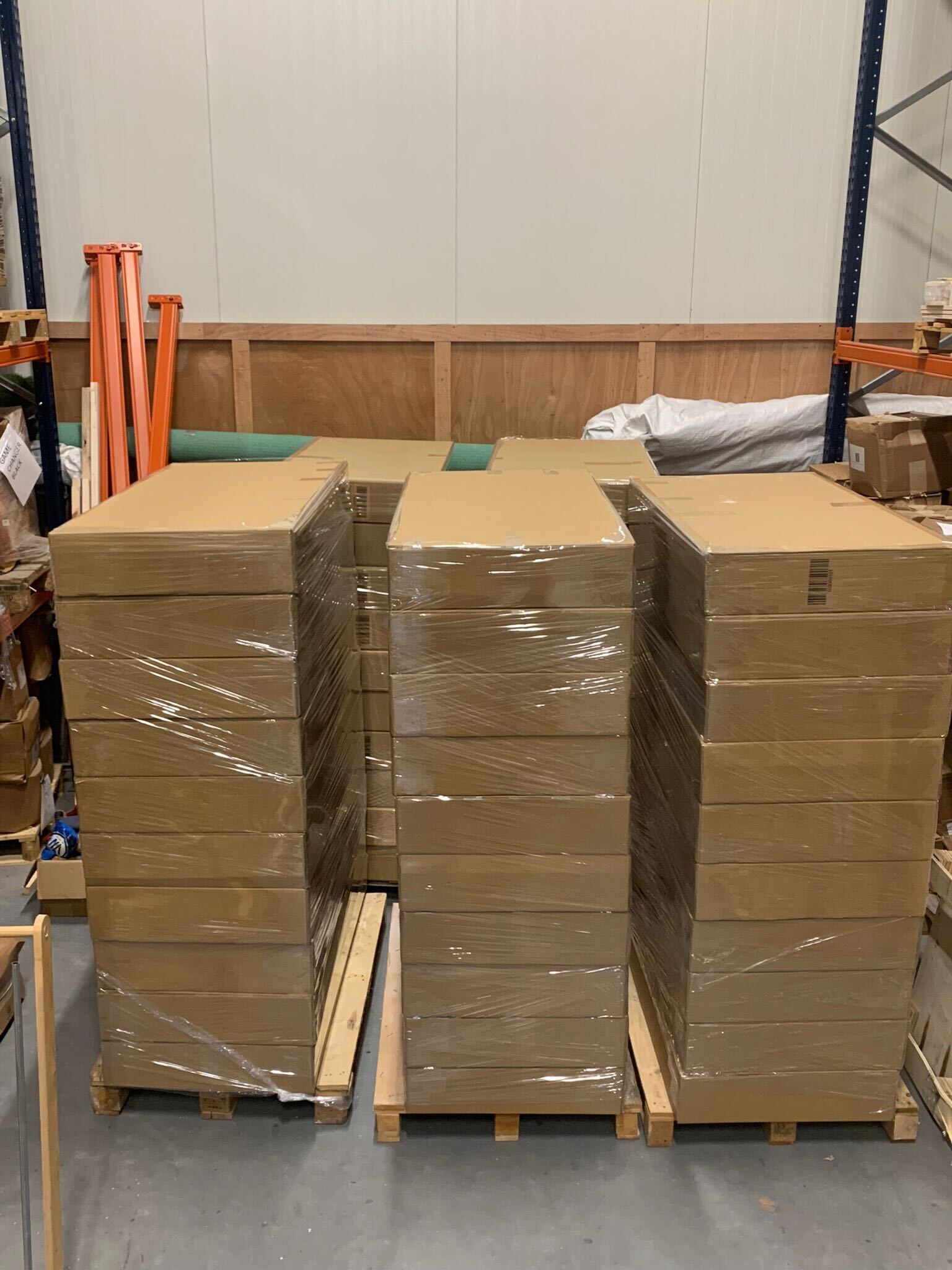 Cornhole borden gestapeld op pallets klaar voor bulk levering